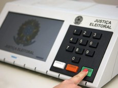 Uma mão votando na Urna eletrônica